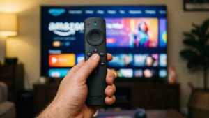 手拿Amazon Fire TV遙控器，在客廳電視上控制串流服務。 — Amazon 壁紙