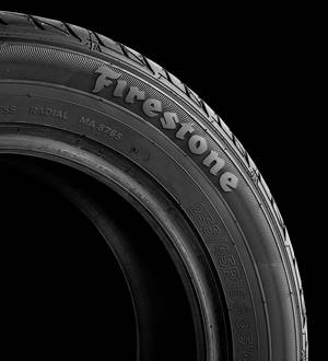 Firestone 輪胎胎面特寫，在黑色背景上可見文字和溝槽。