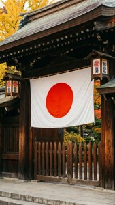 日本國旗懸掛在木製寺廟門上，周圍是秋葉