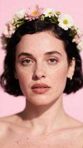 有雀斑的女性戴著花冠，背景是粉紅色