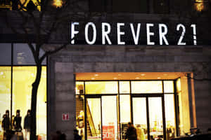 夜晚的Forever 21店面，發光的窗戶和光禿的樹木。 — 午夜 壁紙