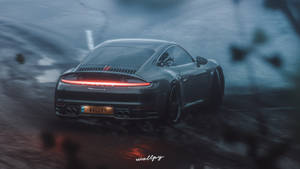 深色保時捷 911 Turbo S 在夜雨中疾馳，尾燈發光。
