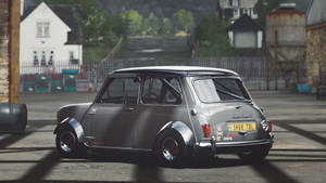 銀色經典Mini Cooper S賽車在工業庭院中，背景有石建築物和綠色植物。