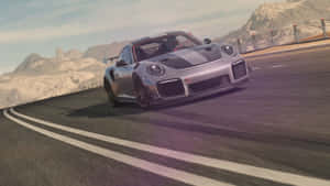 黃昏時分，銀色保時捷 GT2 RS 在山路上奔馳。