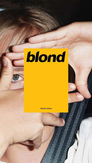 人舉著Frank Ocean的黃色專輯封面《blond》，露出一隻眼睛。