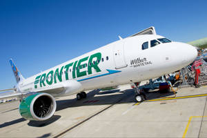 Frontier Airlines飛機在強烈陽光下停泊在機場閘口。