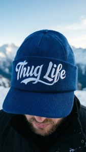 戴藍色帽、有 'Thug Life' 字樣的人站在雪山中