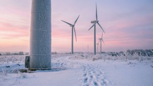 日出時霜凍田野中的積雪風力發電機