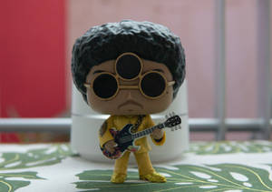 Prince Funko Pop 人偶在圖案桌布上拿著結他。