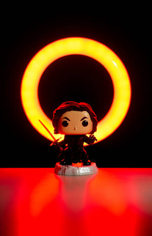 Kylo Ren Funko Pop人偶被發光的橙色環照亮，背景為黑色。