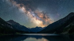 在星空下，寧靜的山湖中反射的銀河系