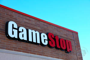 晴朗藍天下磚建築上的GameStop商店招牌 — 遊戲 壁紙