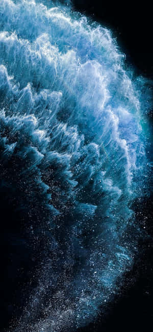 一道強勁的藍色海洋波浪在黑暗背景上撞擊出白色泡沫。 — Galaxy M07 壁紙