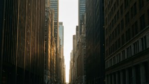 夕陽光線照亮了狹窄城市街道上的高樓大廈。
