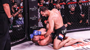 MMA拳手身穿黑色短褲、帶有荷蘭國旗，在八角籠內的墊子上對對手施展裸絞。
