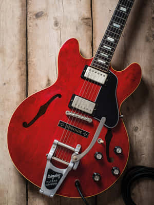 木質表面上帶有 Bigsby 顫音搖把的紅色電結他