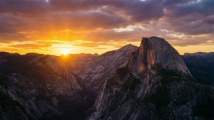半圓頂山被夕陽照亮，崎嶇地形上空有戲劇性的雲彩
