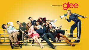 Glee 演員在觀眾席上，教練透過擴音器大喊，背景為黃色。