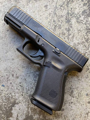 黑色Glock 19 Gen5手槍在紋理混凝土表面上。