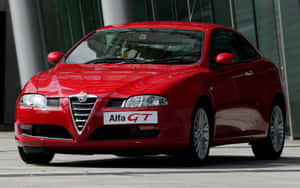 紅色Alfa GT跑車停泊喺玻璃建築前面 — MacBook Air M1 壁紙