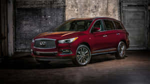 紅色 Infiniti QX60 SUV 停放在光線昏暗的磚砌倉庫中。 — iMac 壁紙