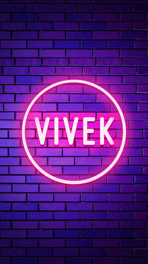 夜間磚牆上帶有名字 Vivek 的霓虹燈牌。