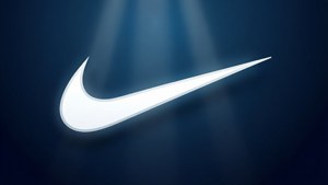 在深藍色背景上，聚光燈光束下的發光白色Nike swoosh標誌