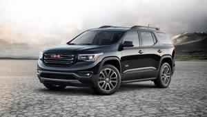 黑色GMC Acadia SUV停泊在龜裂的沙漠地面，背景有山脈。 — 酷車 壁紙