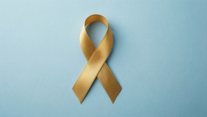 金色意識絲帶喺藍色背景上，用嚟表達支持同團結。