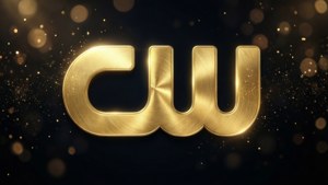 金色CW標誌，帶有拉絲金屬紋理，在黑暗背景上閃爍的燈光