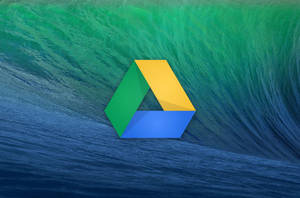 Google Drive 標誌在一個破碎的海浪前。
