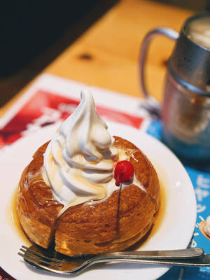 金黃色糕點配鮮奶油、焦糖和櫻桃，放在白色碟子上，附叉子。 — 班戟 壁紙