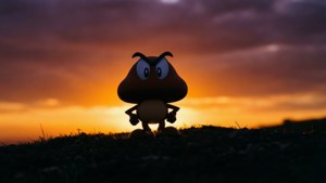 Goomba玩具剪影，背景為橙色和紫色的日落天空，位於草地上。