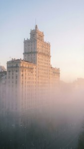 城市中一座高聳裝飾建築物的霧晨景觀。