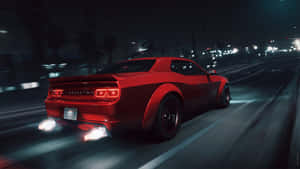 紅色肌肉車在夜間穿過城市，排氣管火焰發光。