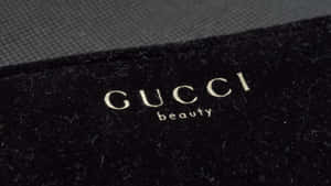 Gucci beauty標誌在黑色天鵝絨布料上，帶紋理灰色背景。