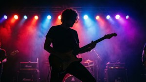 一位音樂家在現場音樂會中，在色彩繽紛的舞台燈光下彈奏電結他。