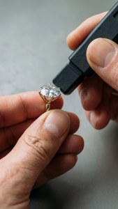 用專業工具測試鑽石戒指的雙手。