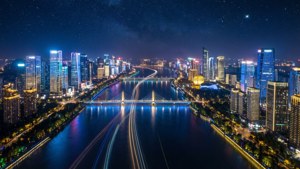 夜晚的未來城市天際線，發光的建築物和河流上的光跡，星空下