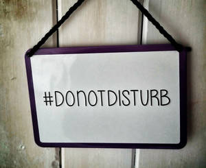 一個帶紫色邊框和「#DONOTDISTURB」的標誌掛在木門上。 — 簡單 壁紙