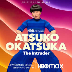Atsuko Okatsuka 身穿藍色服裝，在色彩繽紛的背景上為HBO喜劇特別節目拍攝。