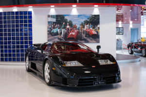 黑色Bugatti跑車在博物館中展出，有藍色玻璃牆和賽車海報。 — 布加迪 壁紙