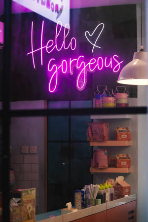 夜間咖啡館內一個寫著「Hello gorgeous」的紫色霓虹燈牌。