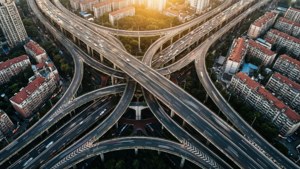 日落時分，複雜的高速公路交匯處，汽車行駛，周圍城市建築