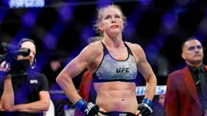 女性MMA拳手在UFC八角籠中於場館燈光下慶祝勝利。 — 搏擊會 GIF 壁紙
