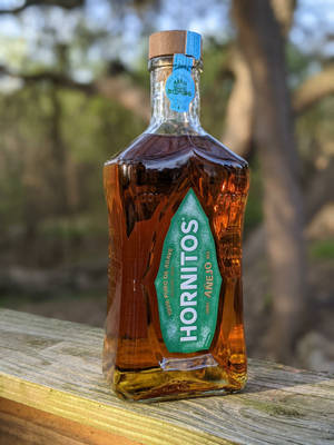 戶外木質表面上的Hornitos Añejo龍舌蘭酒瓶