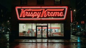 一間 Krispy Kreme 冬甩店，在潮濕的城市街道上，夜晚有明亮的紅色霓虹燈牌發光。