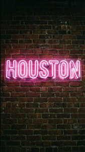 夜間安裝在磚牆上的粉紅色霓虹燈 houston 標誌