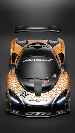 在黑暗的攝影棚中從上方看到的橙色和黑色McLaren Senna GTR賽車。