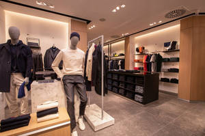 光線充足的男裝店，有人體模型和整齊排列的服裝。